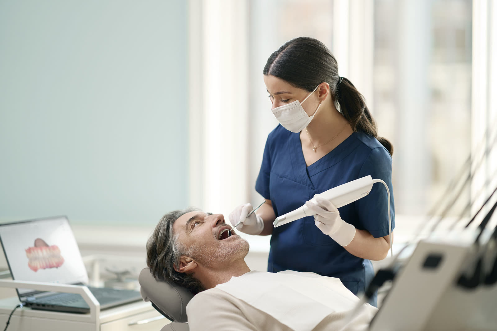 A patient being scanned chairside with the handheld 3Shape TRIOS intraoral scanner